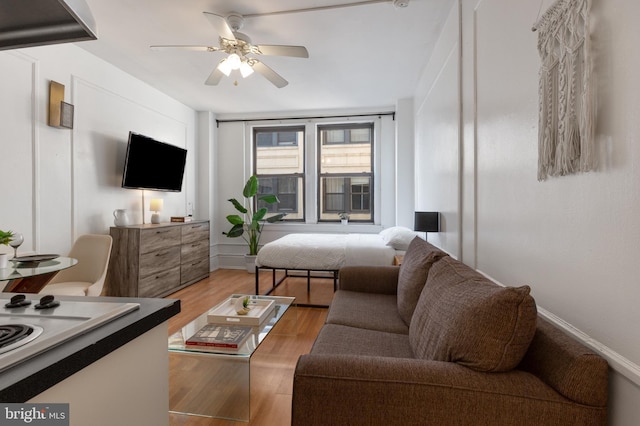 living room with a ceiling fan and light wood-type flooring