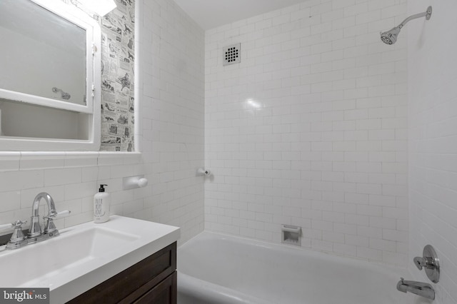 bathroom with  shower combination, tile walls, backsplash, and vanity