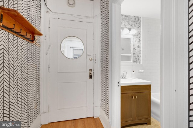 bathroom with tile walls, vanity, and wood-type flooring