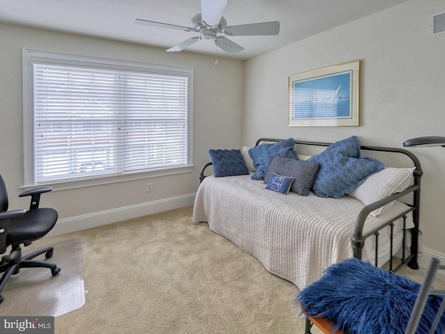 bedroom with multiple windows, ceiling fan, and light colored carpet