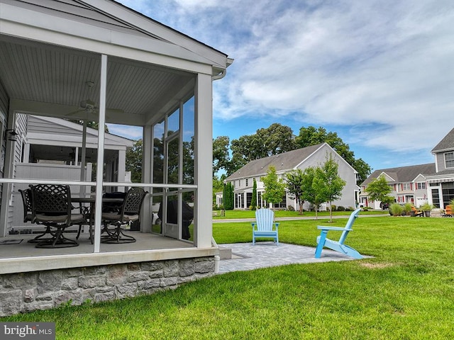 view of yard with a patio area, a sunroom, and ceiling fan