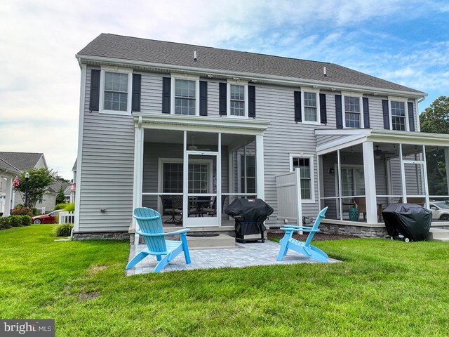 back of house featuring a sunroom, a patio, and a lawn