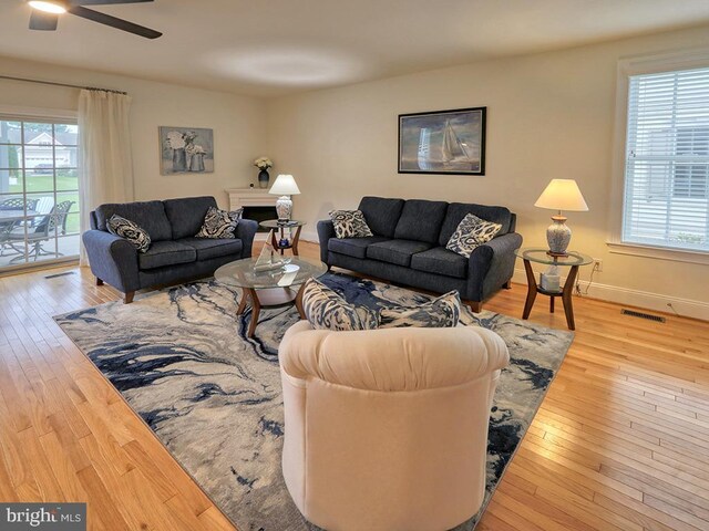 living room with light hardwood / wood-style flooring, ceiling fan, and plenty of natural light