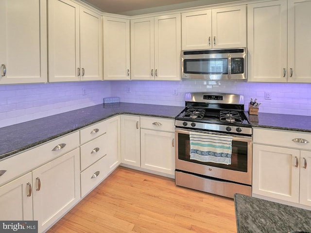 kitchen featuring white cabinetry, decorative backsplash, light wood-type flooring, and stainless steel appliances