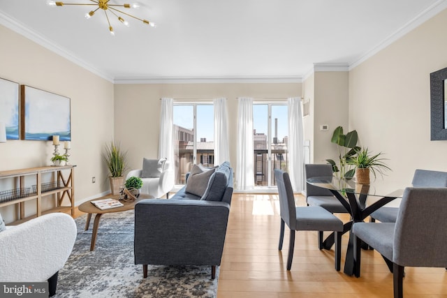 living area featuring crown molding, light wood-style flooring, baseboards, and an inviting chandelier