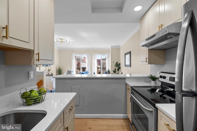 kitchen with stainless steel appliances, light countertops, a peninsula, light wood-type flooring, and under cabinet range hood