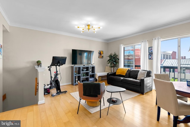 living room featuring a notable chandelier, light wood-type flooring, and crown molding