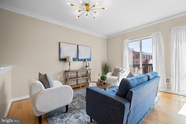 living area with baseboards, ornamental molding, hardwood / wood-style floors, and an inviting chandelier