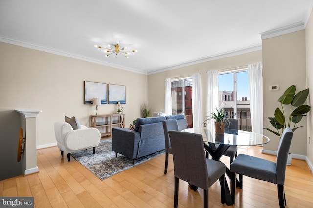 dining area featuring light wood finished floors, a chandelier, and crown molding