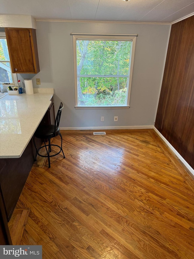 dining area featuring hardwood / wood-style flooring, crown molding, and plenty of natural light