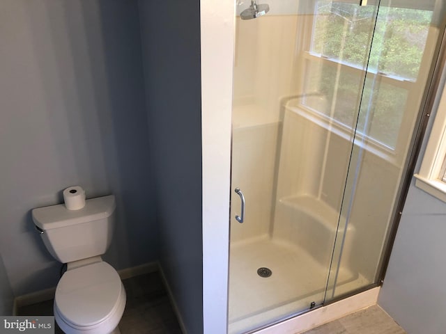 bathroom with an enclosed shower and toilet