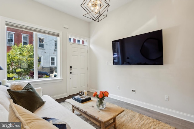 living room featuring dark wood-type flooring and a notable chandelier