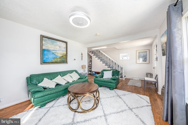 living room with wood-type flooring and a textured ceiling