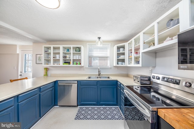 kitchen featuring appliances with stainless steel finishes, blue cabinets, sink, and a textured ceiling