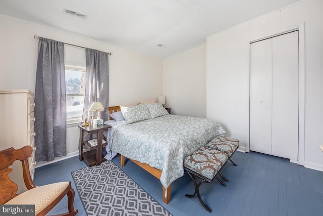 bedroom with dark hardwood / wood-style flooring and a closet