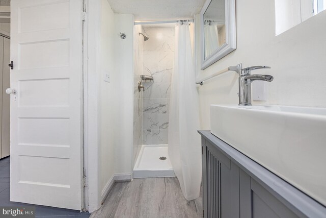 bathroom featuring a textured ceiling, vanity, wood-type flooring, and a shower with curtain