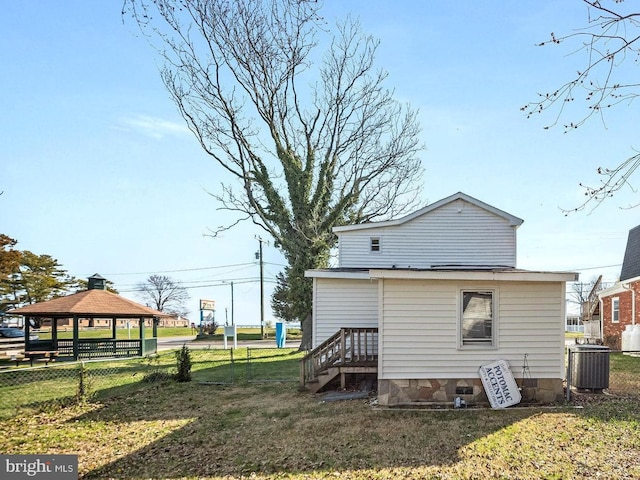 back of property with a gazebo, a yard, and central AC unit