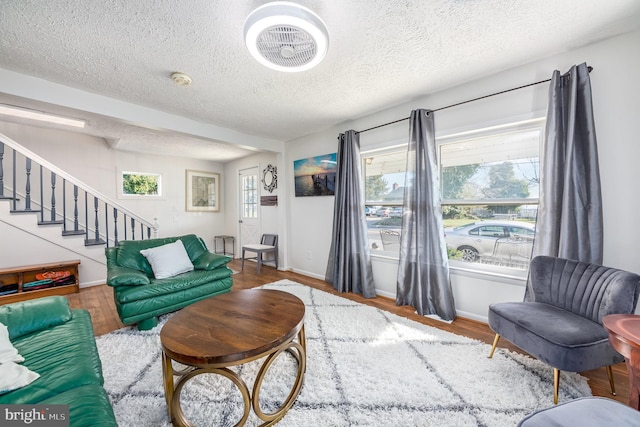 living room featuring a textured ceiling and wood-type flooring