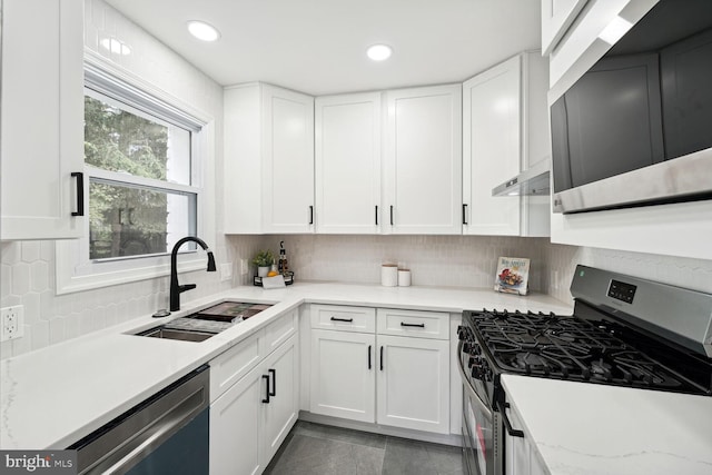 kitchen featuring appliances with stainless steel finishes, sink, tasteful backsplash, and white cabinets