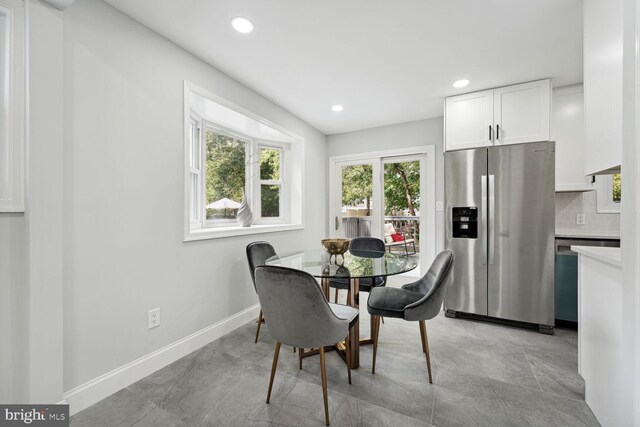 kitchen with sink, backsplash, white cabinets, and appliances with stainless steel finishes