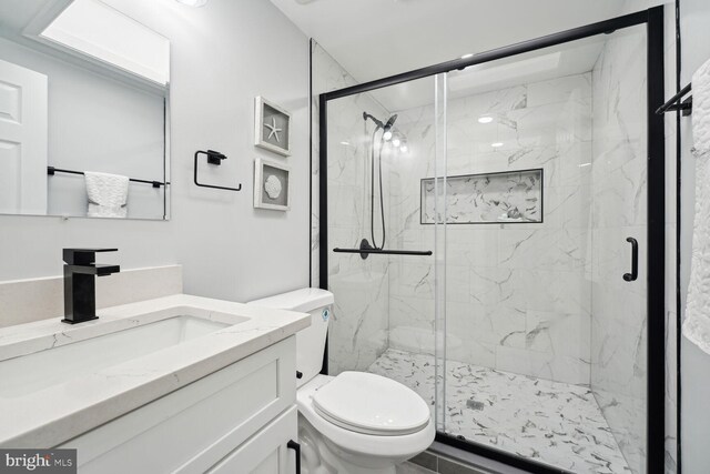 bathroom featuring vanity, toilet, and walk in shower