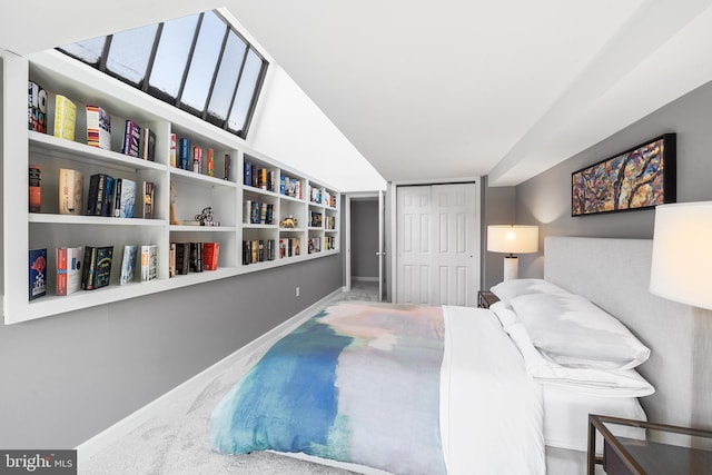 carpeted bedroom featuring a closet and lofted ceiling