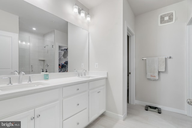 bathroom with dual vanity, walk in shower, and tile patterned flooring