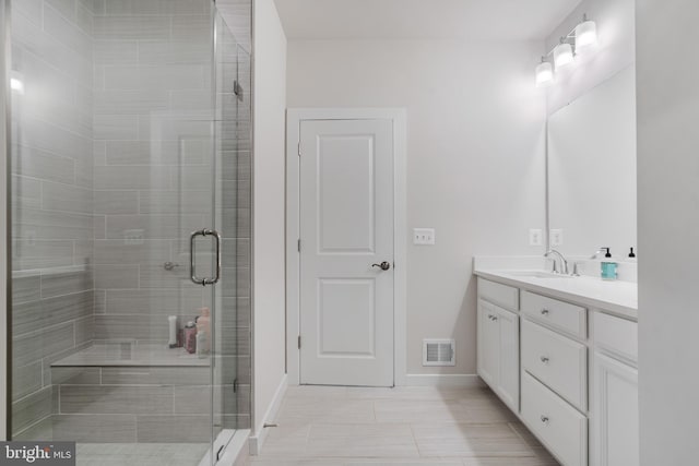 bathroom with tile patterned flooring, an enclosed shower, and vanity