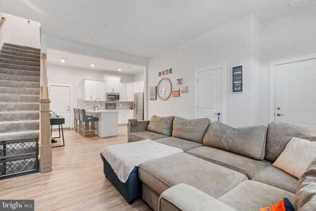 living room featuring sink and light wood-type flooring