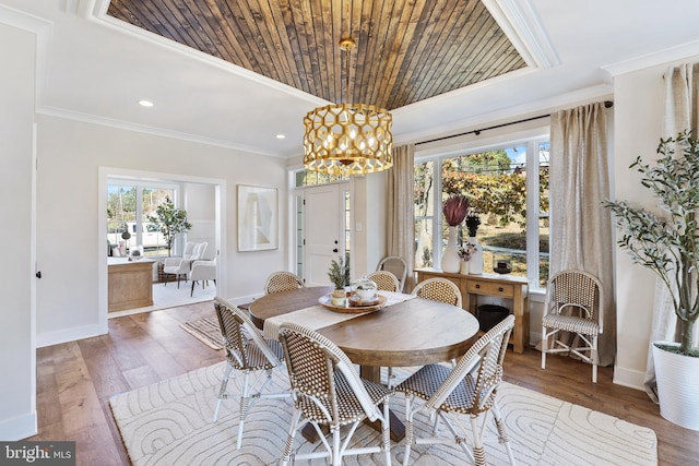 dining space with hardwood / wood-style flooring, a healthy amount of sunlight, and ornamental molding