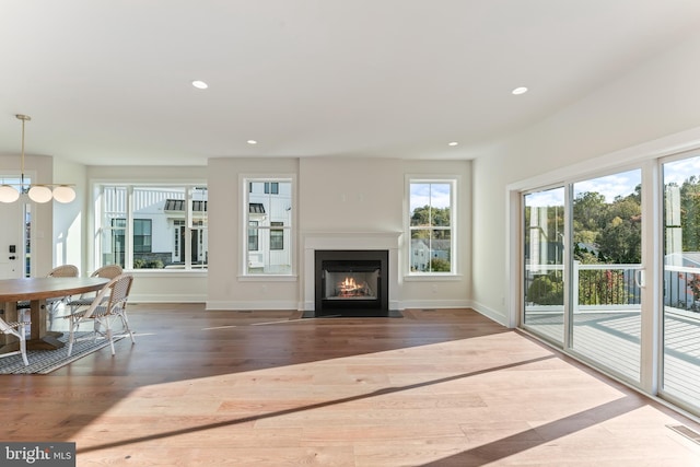 unfurnished living room featuring hardwood / wood-style flooring and a notable chandelier