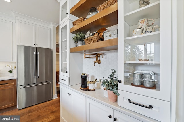 kitchen featuring stainless steel refrigerator, wood-type flooring, and white cabinets