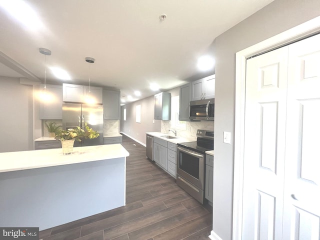 kitchen featuring gray cabinetry, tasteful backsplash, appliances with stainless steel finishes, and pendant lighting