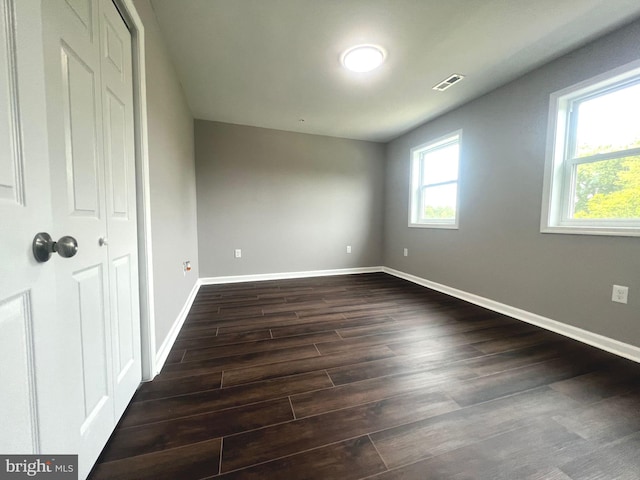 unfurnished bedroom with dark hardwood / wood-style flooring and a closet