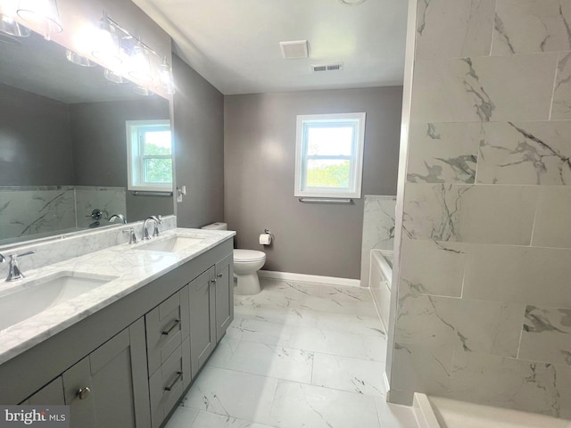 bathroom featuring dual vanity, toilet, tile patterned flooring, and a wealth of natural light