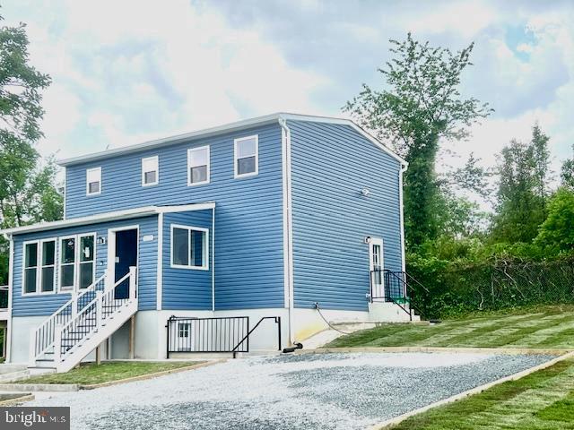 rear view of property featuring a lawn