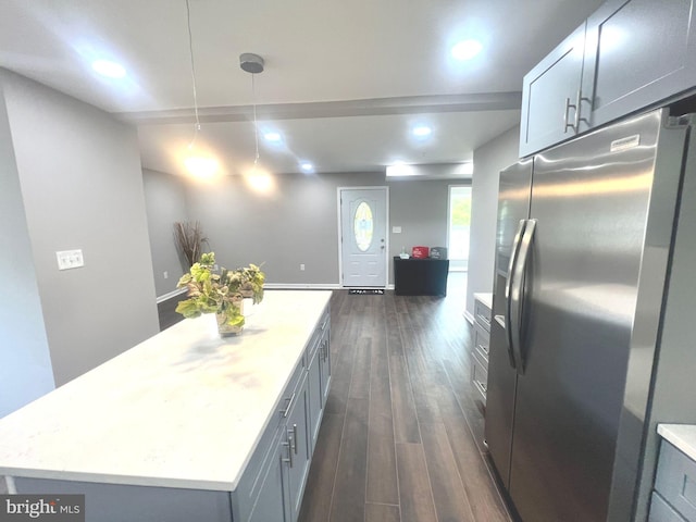 kitchen featuring dark hardwood / wood-style flooring, stainless steel refrigerator with ice dispenser, light stone countertops, gray cabinetry, and a kitchen island