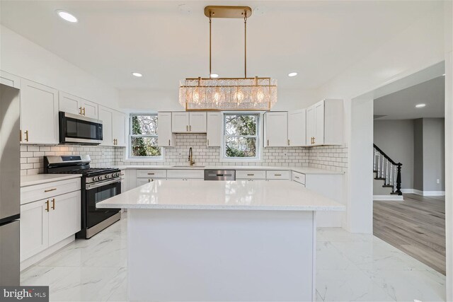 kitchen with light hardwood / wood-style flooring, stainless steel appliances, and white cabinets