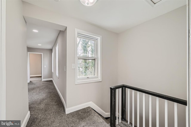 corridor featuring dark colored carpet