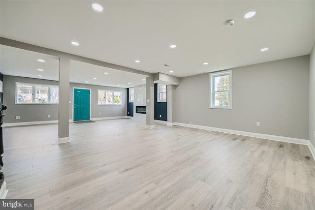 unfurnished living room with a wealth of natural light and light wood-type flooring