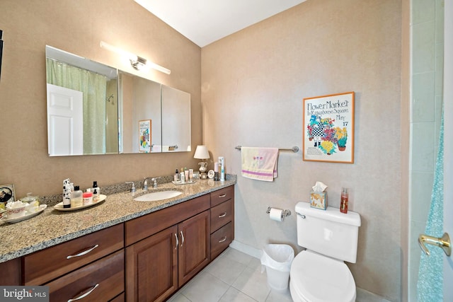 bathroom with toilet, vanity, and tile patterned floors