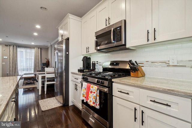 kitchen featuring stainless steel appliances, dark hardwood / wood-style floors, decorative backsplash, white cabinets, and light stone counters