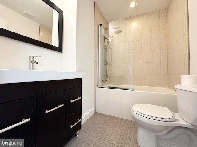 full bathroom with tiled shower / bath combo, tile patterned floors, toilet, and vanity