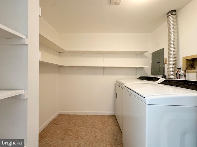 laundry room featuring washing machine and clothes dryer, electric panel, and light tile patterned floors