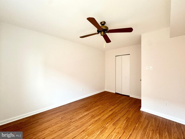 unfurnished bedroom featuring hardwood / wood-style flooring, a closet, and ceiling fan