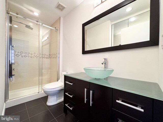 bathroom featuring vanity, walk in shower, tile patterned flooring, and toilet