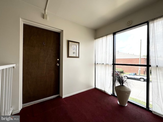 interior space featuring dark carpet and a wealth of natural light