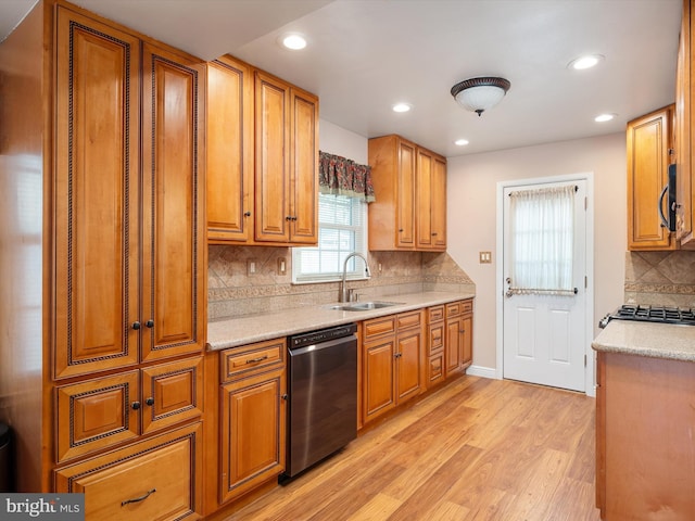 kitchen with tasteful backsplash, sink, stainless steel appliances, and light hardwood / wood-style floors