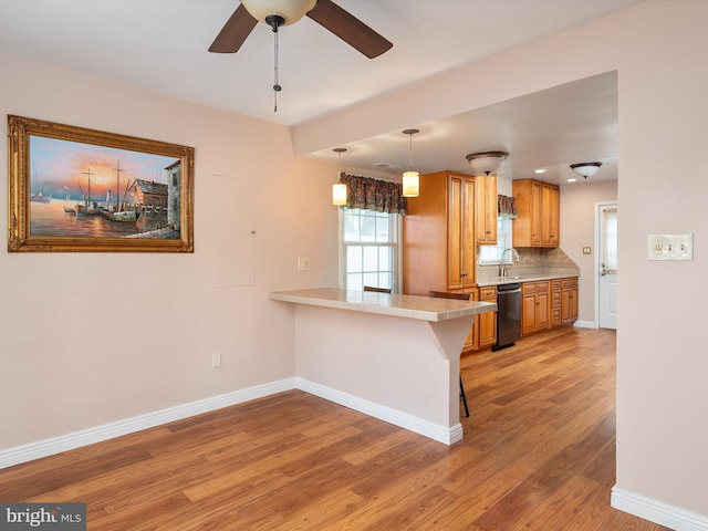 kitchen with sink, a breakfast bar area, tasteful backsplash, black dishwasher, and kitchen peninsula