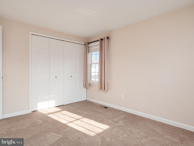 unfurnished bedroom with carpet flooring and a closet